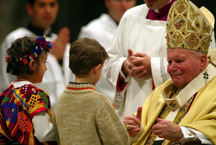 VATICAN MIDNIGHT CRISTMAS MASS POPE:epa000335097 Pope John Paul II (R) smiles at two children dressed in their folkloristic dresses Friday 24 December 2004 in the St. Peter's Basilica during the Midnight Christmas Mass. The Pope defied old age and illness to lead the traditional Christmas Eve midnight Mass in a ceremony that was broadcast live to more than 70 countries around the world. EPA/GIUSEPPE GIGLIA