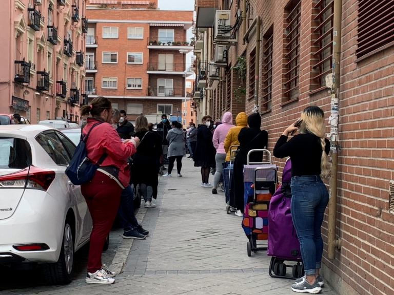 GRAF9028. MADRID, 21/05/2020.- Vista de la fila de clientes que aguardan su turno para entrar al economato de Cáritas en el distrito madrileño de Tetuán, donde familias y personas necesitadas pueden comprar alimentos y otros productos de primera necesidad a precio subvencionado. La crisis causada por la pandemia ha golpeado duro a las comunidades de latinoamericanos en España, con frecuencia en el nivel más frágil de la escala social, y ahora muchos de ellos se ven abocados a la pobreza y a la ayuda para sobrevivir. A menudo atrapados en empleos temporales o informales, los latinos se han visto afectados de forma desmedida por el huracán que se ha llevado por delante, hasta ahora, casi 950.000 empleos. EFE/Rafael Cañas